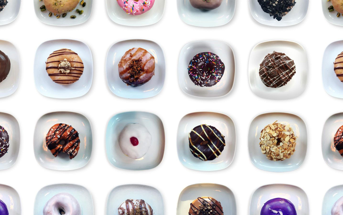 Composite image of many plates of doughnuts in a variety of unique flavours.